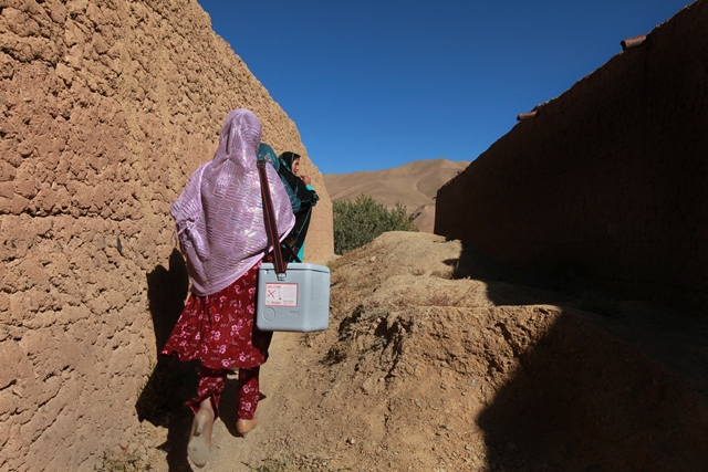 Afghan female health workers going door-to-door to vaccinate children against polio. Photo: Eric Kanalstein / UNAMA