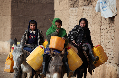 In this photo, Afghan girls in the northern Afghan province of Balkh head out to fetch drinking water from a nearby river. Photo: Fardin Waezi / UNAMA