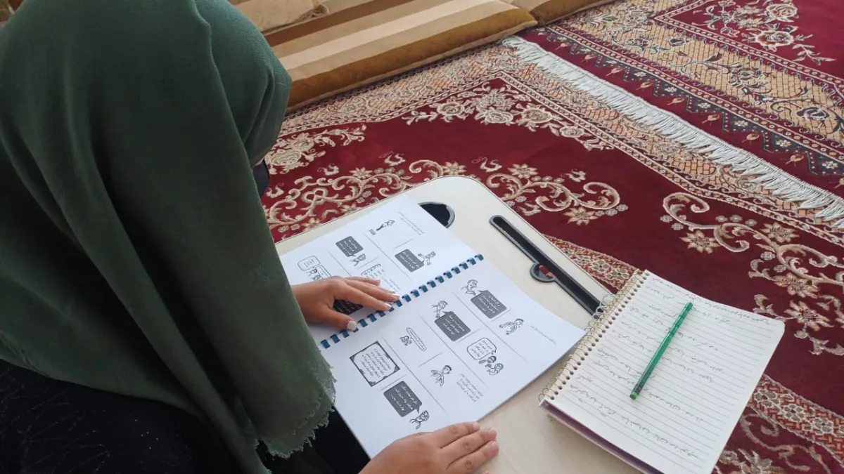 Afghan woman following a radio-based literacy program