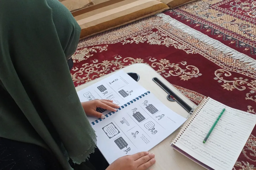 Afghan woman following a radio-based literacy program